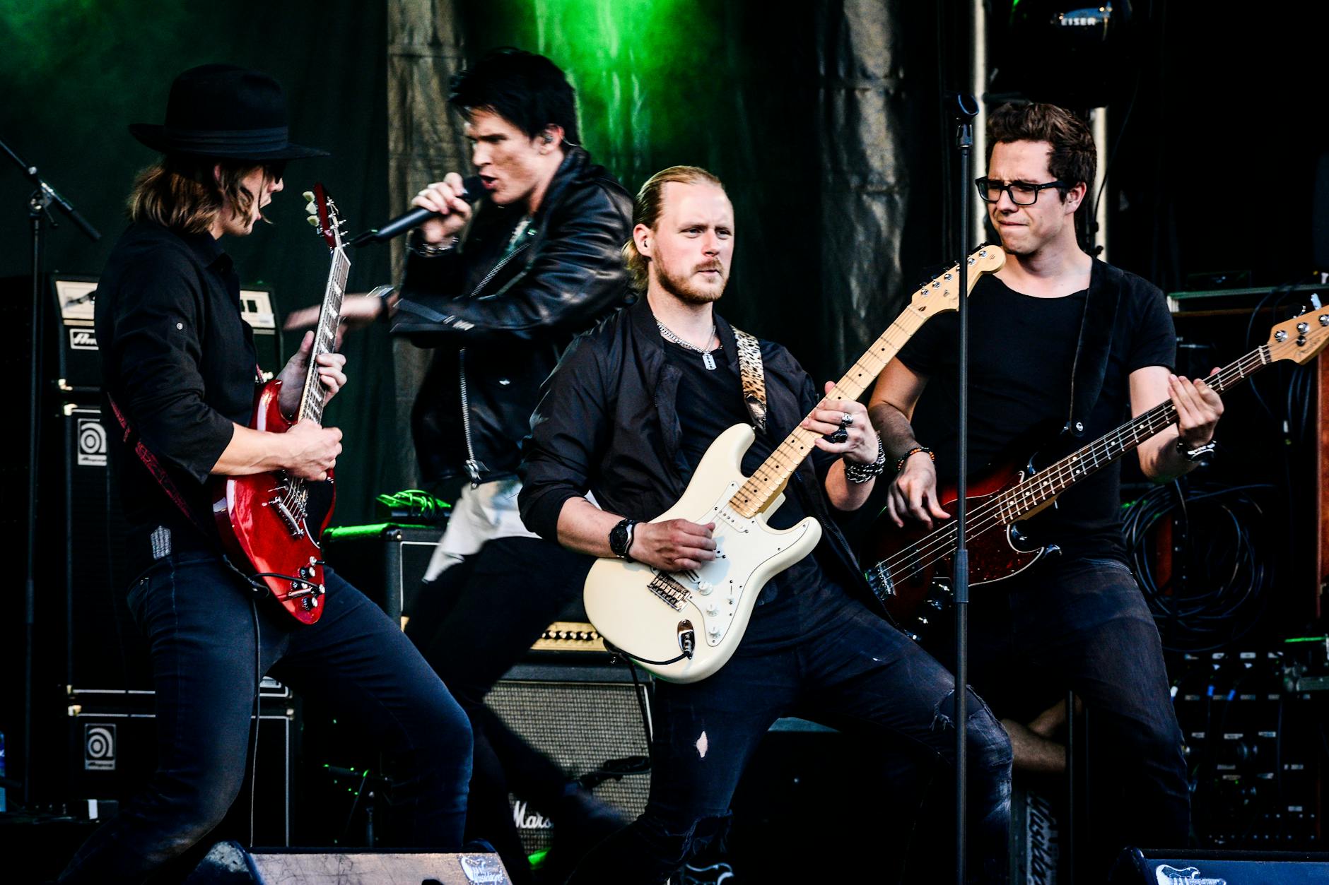 Rockowy zespół grający na żywo na scenie z gitarami i mikrofonem