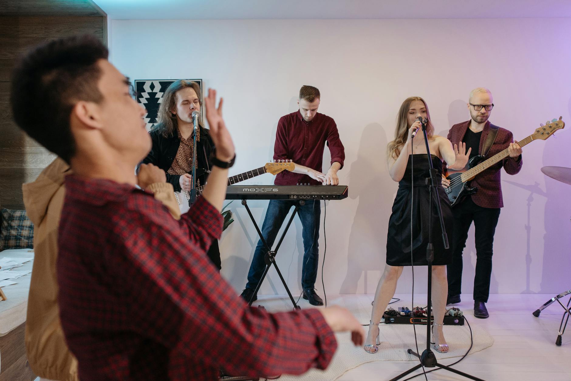 Zespół grający na żywo na scenie przed bawiącą się publicznością