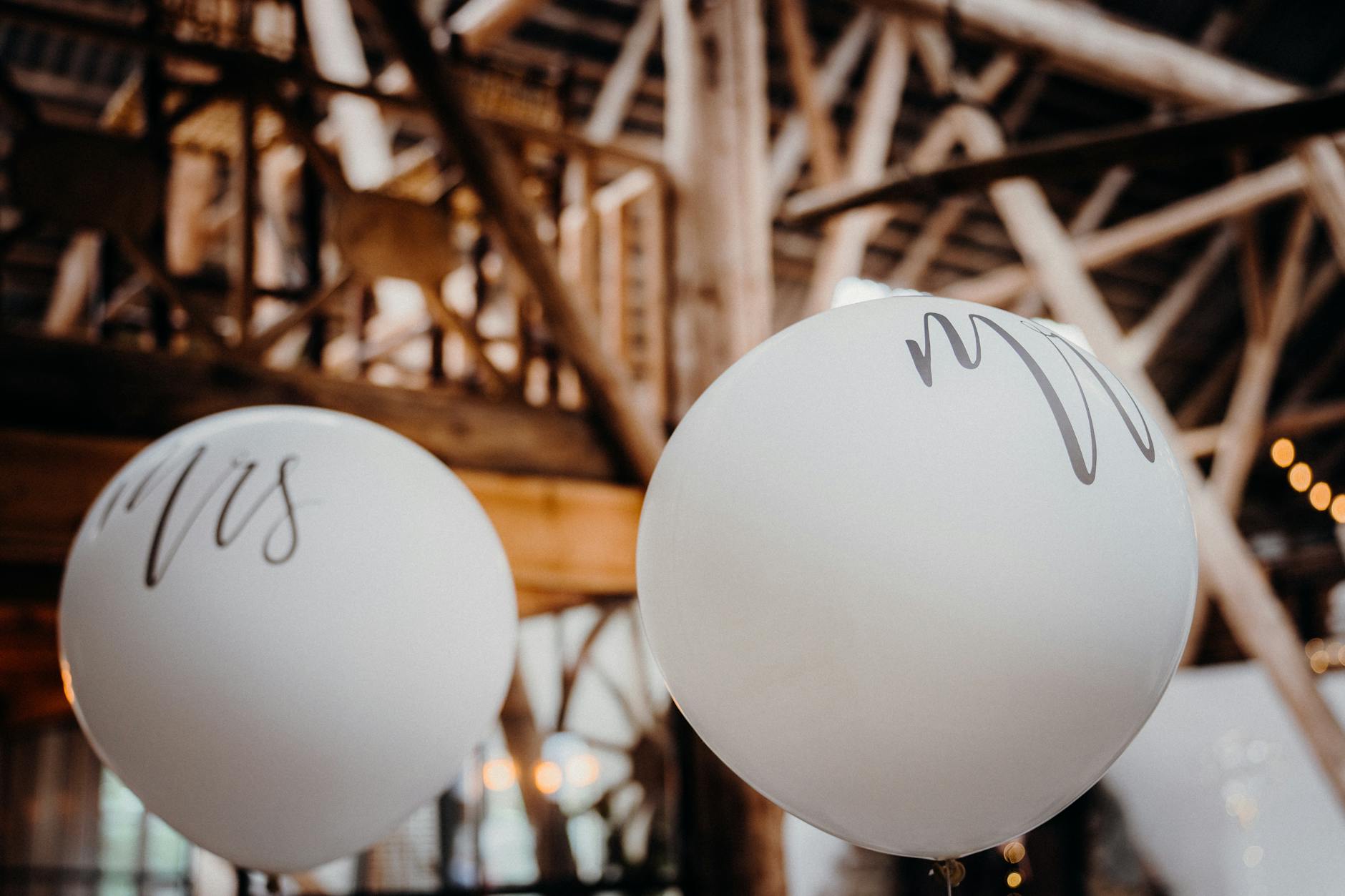 Białe balony weselne w rustykalnej sali jako tania dekoracja