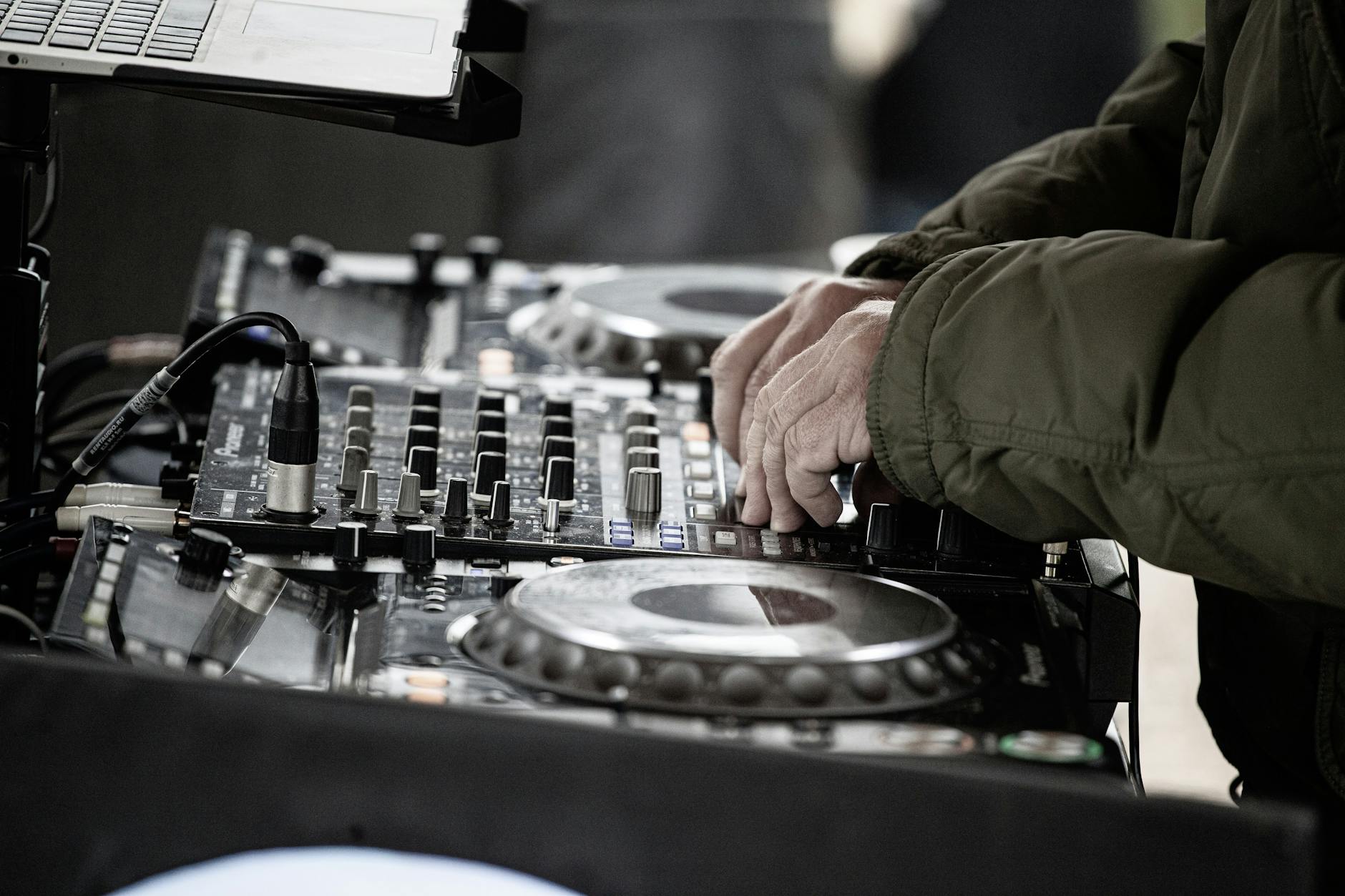DJ miksuje muzykę na profesjonalnym mikserze podczas plenerowego występu
