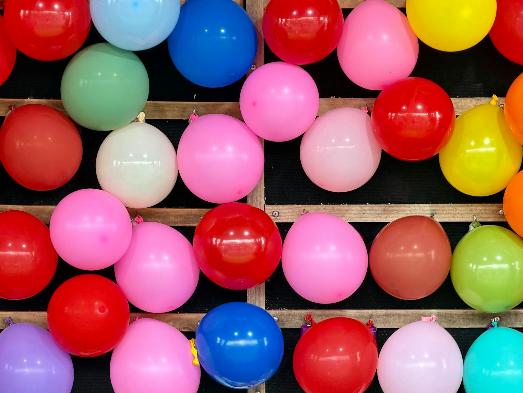 Kolorowe balony na stoisku festynowym wesoło unoszące się w górze