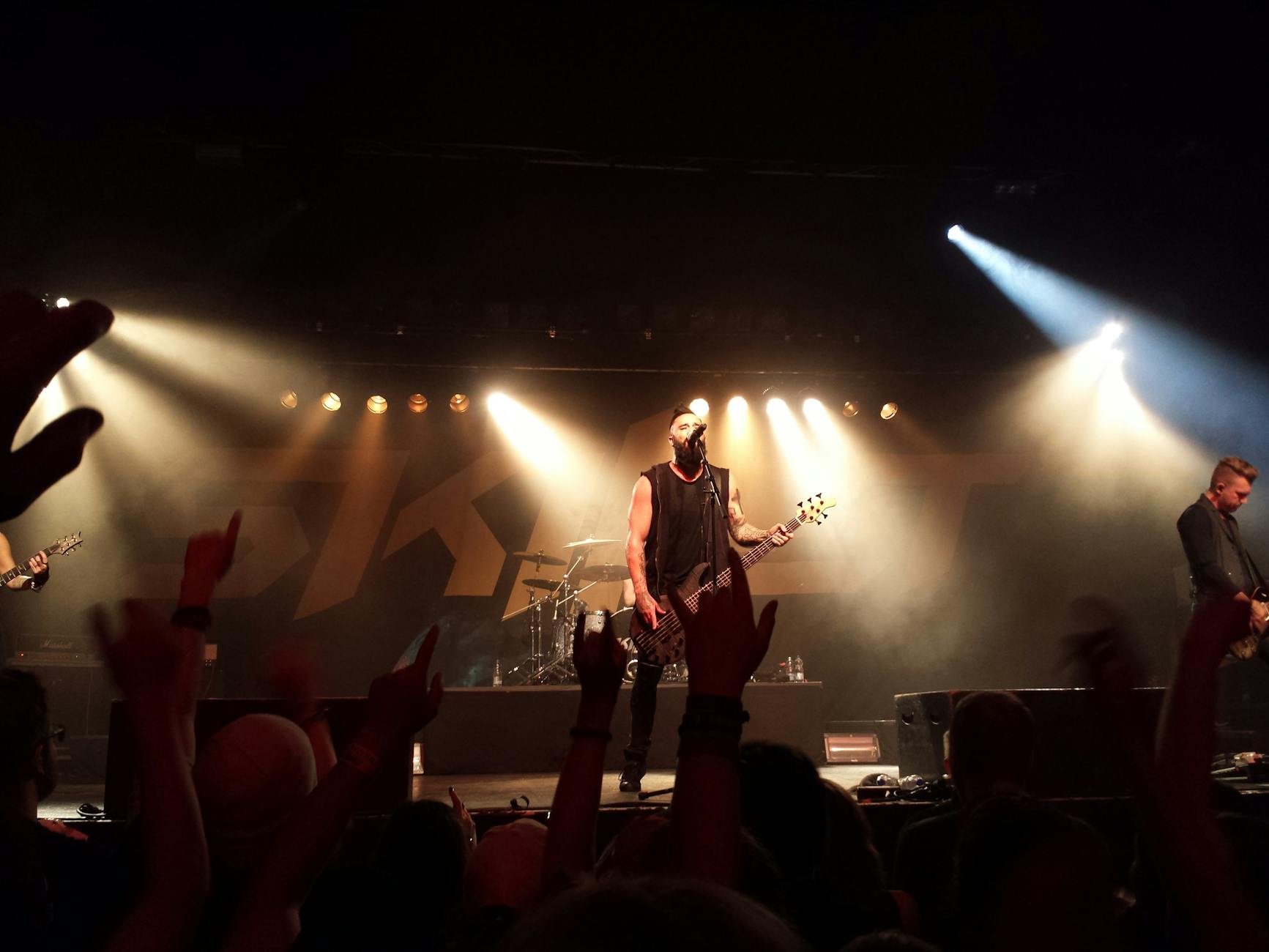 Rockowy zespół gra na żywo na scenie przy kolorowych światłach