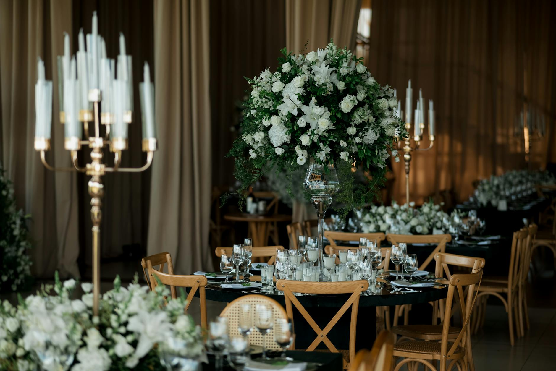 Elegancka sala weselna z kwiatami i świecami na stołach
