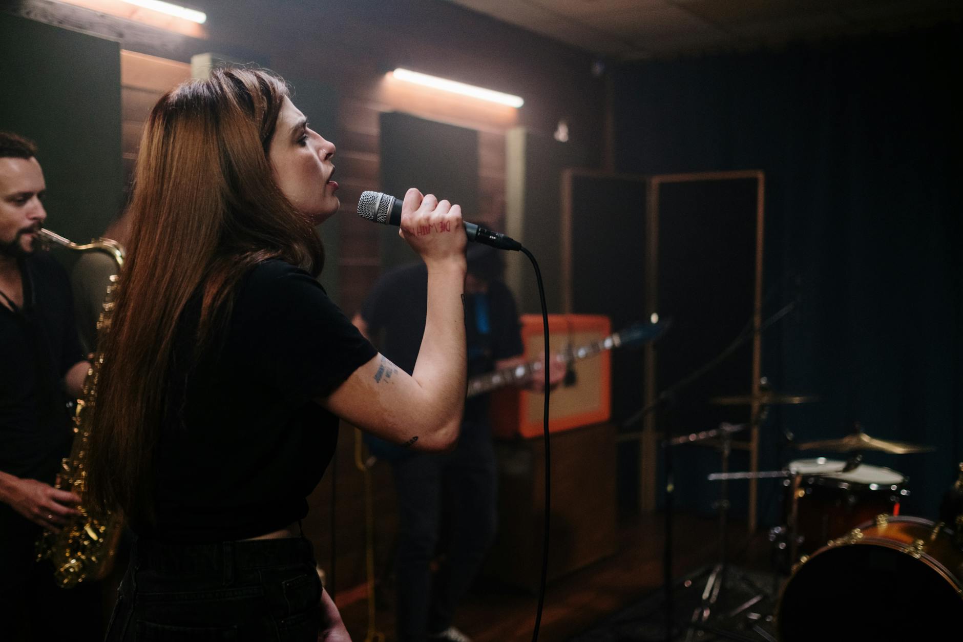 Zespół indie ćwiczący repertuar w studiu, wokalistka śpiewa do mikrofonu