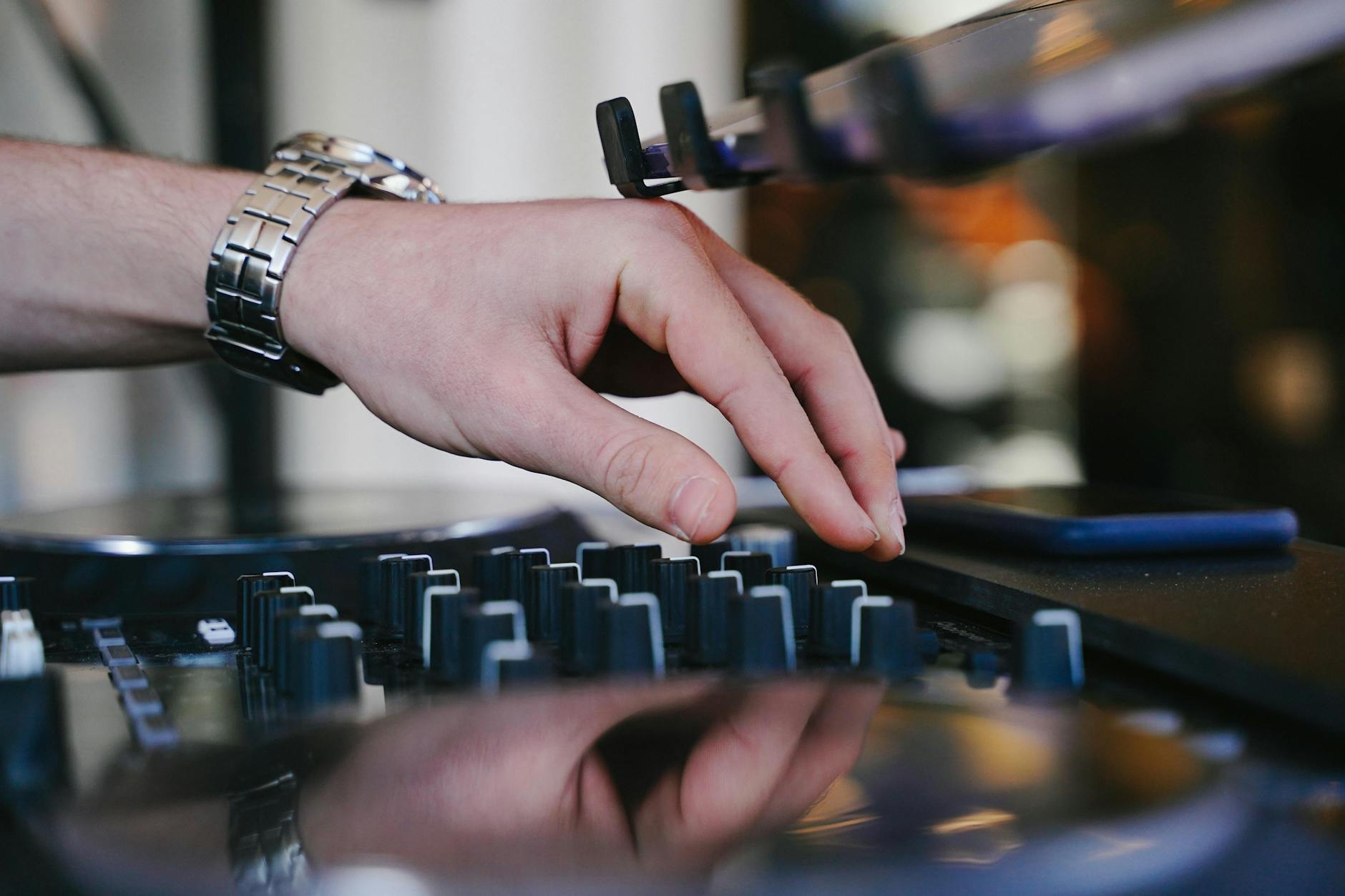 Dłoń DJ-a regulująca pokrętła miksera podczas występu na żywo Dłoń DJ-a regulująca pokrętła miksera podczas występu na żywo