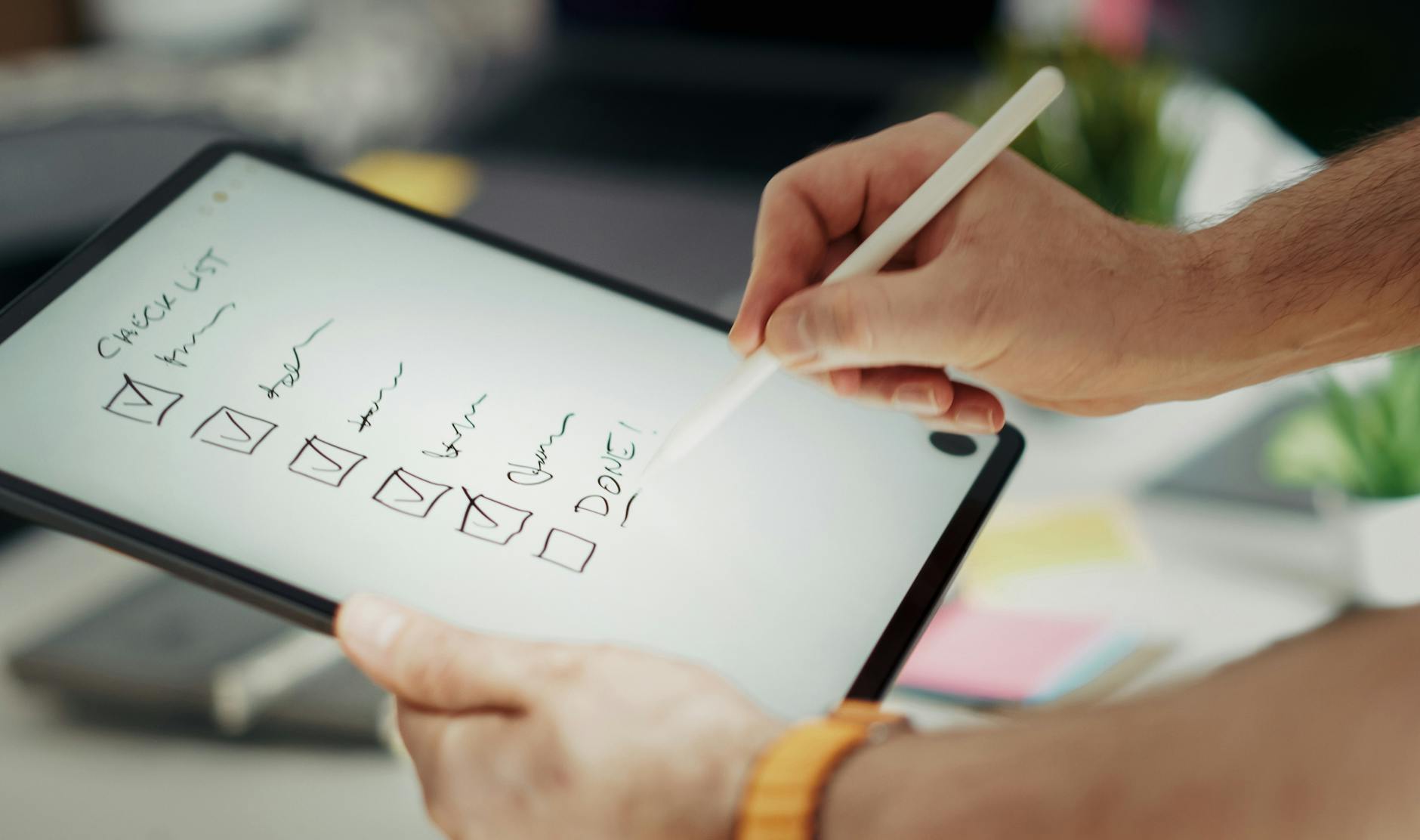 Dłoń zapisująca harmonogram wesela rysikiem na tablecie