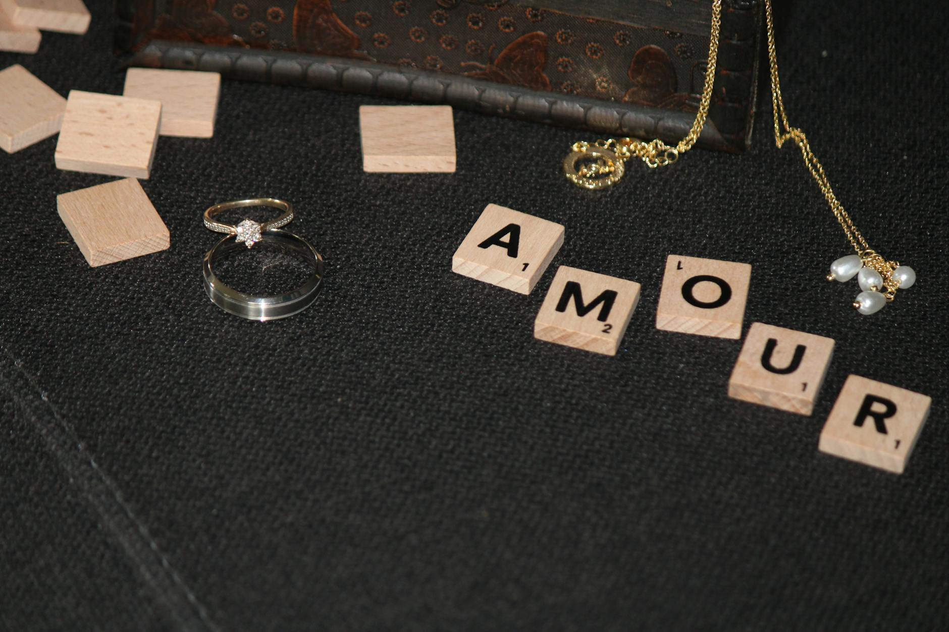 Obrączki ślubne i klocki scrabble układające się w napis amour