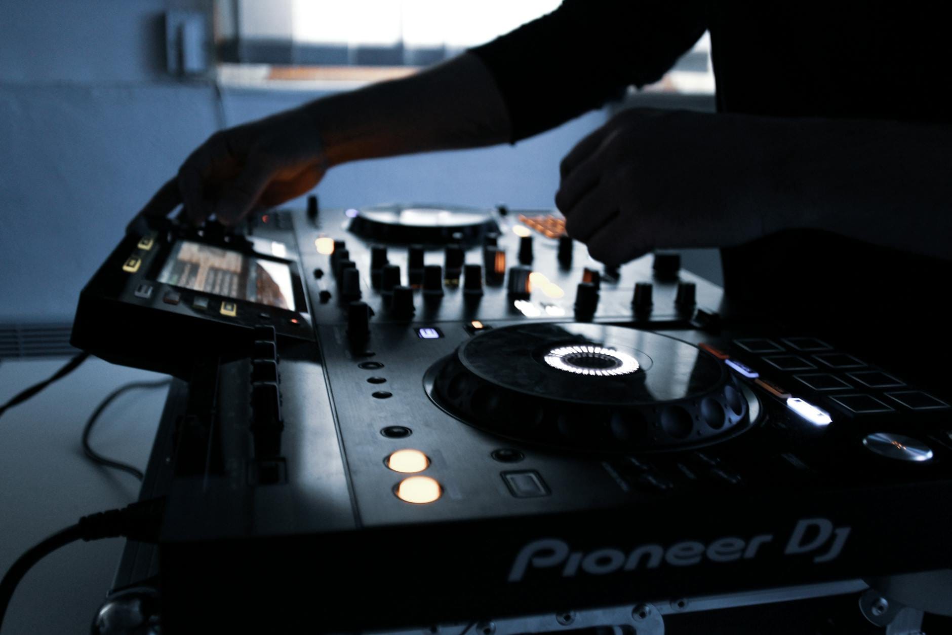 Sprzęt DJ-a w ciemnym pomieszczeniu podczas miksowania muzyki Sprzęt DJ-a w ciemnym pomieszczeniu podczas miksowania muzyki